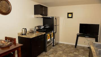 Suite de base, 1 très grand lit, cuisine | Cuisine privée | Réfrigérateur, four à micro-ondes, cafetière-théière
