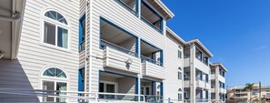 A multi-story hotel with balconies, large windows, and a clear blue sky. - Capistrano Surfside Inn (Dana Point)