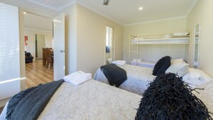 A bedroom with two beds, a ceiling fan, and a bunk bed.