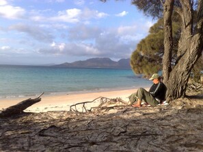 Nära stranden, vit sandstrand, parasoller och strandhanddukar