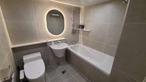 Ein modernes Badezimmer mit Toilette, Waschbecken und Badewanne.