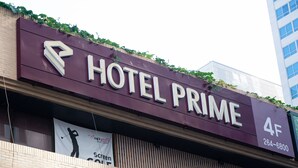 A sign for Hotel Prime with a directional arrow, a contact number, and a banner advertising a golf event. - Hotel Prime Changwon (Changwon)