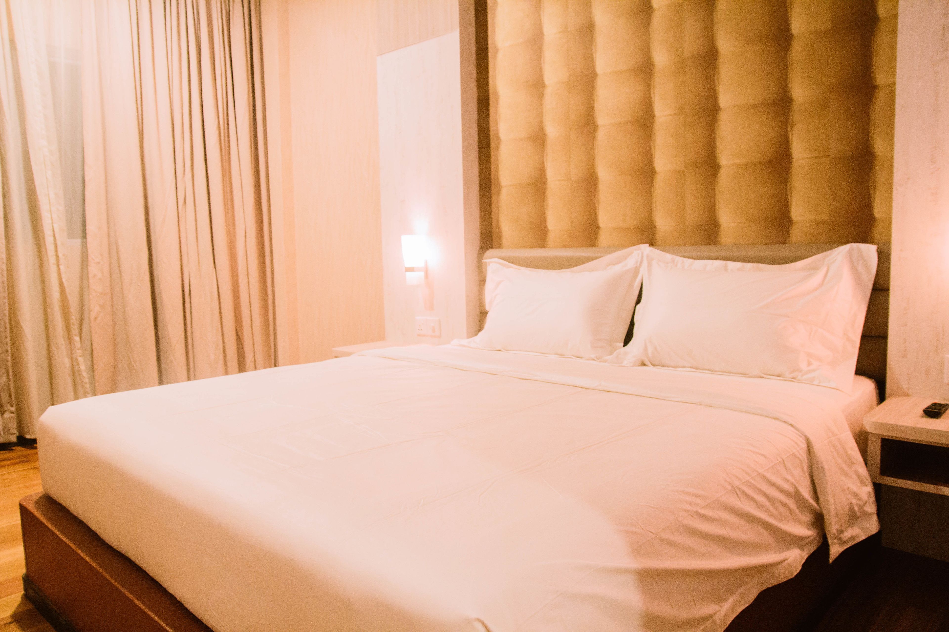 Ein ordentlich bezogenes Bett mit weißen Leinen in einem Hotelzimmer.