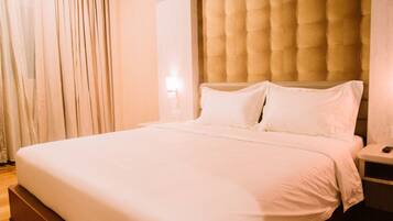 Ein ordentlich bezogenes Bett mit weißen Leinen in einem Hotelzimmer.
