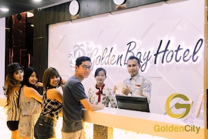 Eine Rezeption im Golden Boy Hotel mit einem gut sichtbaren Logo und einer Uhr darüber.