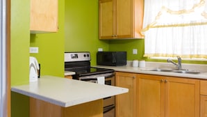 Cocina compacta con microondas, estufa y pileta.