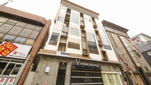 A multi-story building with a 'V hotel parking' sign, indicating a hotel parking facility. - Number25 Hotel (Busan)