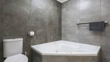 Un baño con bañera, inodoro y toallero.