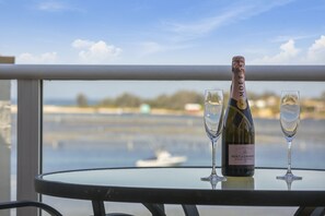 A bottle of Moet & Chandon champagne on a table with two glasses, overlooking a body of water.