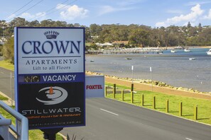 A sign for Crown Apartments advertising a lift to all floors and a vacancy.