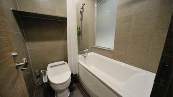 A bathroom with a toilet, a bathtub, and a shower.