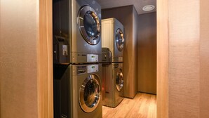 Una sala de bugaderia amb dues rentadores LG i una assecadora.