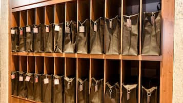 A wooden shelf with multiple fabric bags, each with a tag.