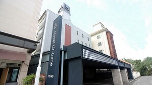 A hotel entrance with a covered parking area and a modern building facade. - Chuncheon Urbane Hotel (Chuncheon)