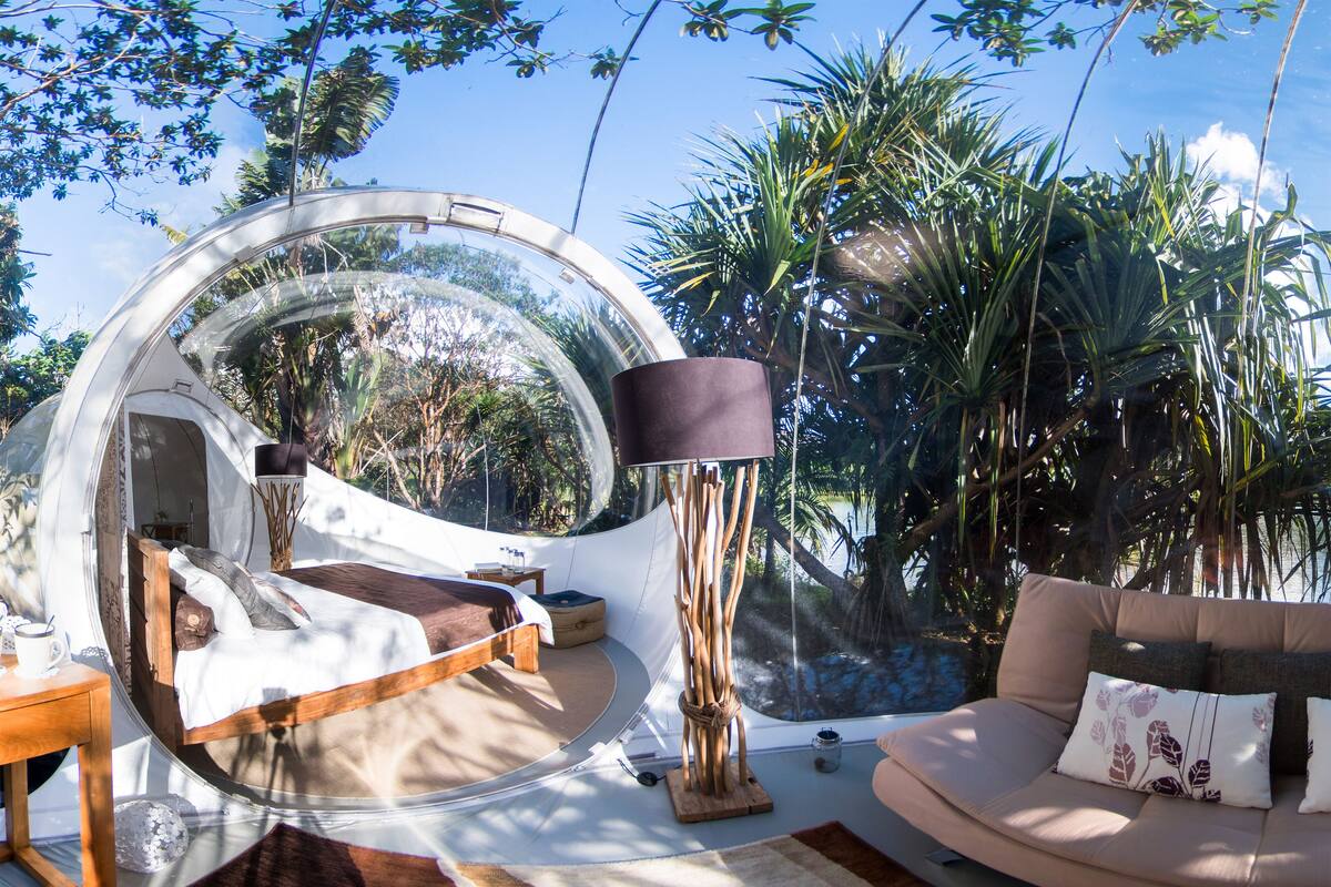 A circular room with a bed, a sofa, and a lamp.