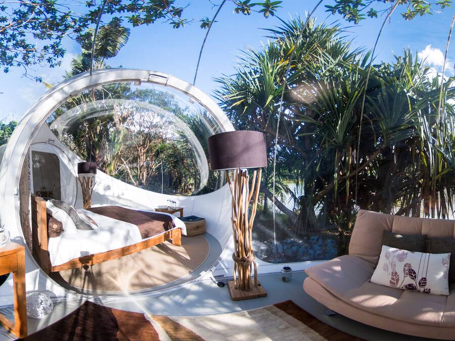 Una habitación circular con una cama, un sofá y una lámpara.