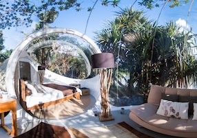 Una habitación circular con una cama, un sofá y una lámpara.