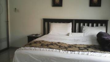 Una cama bien hecha con sábanas blancas y una manta decorativa.