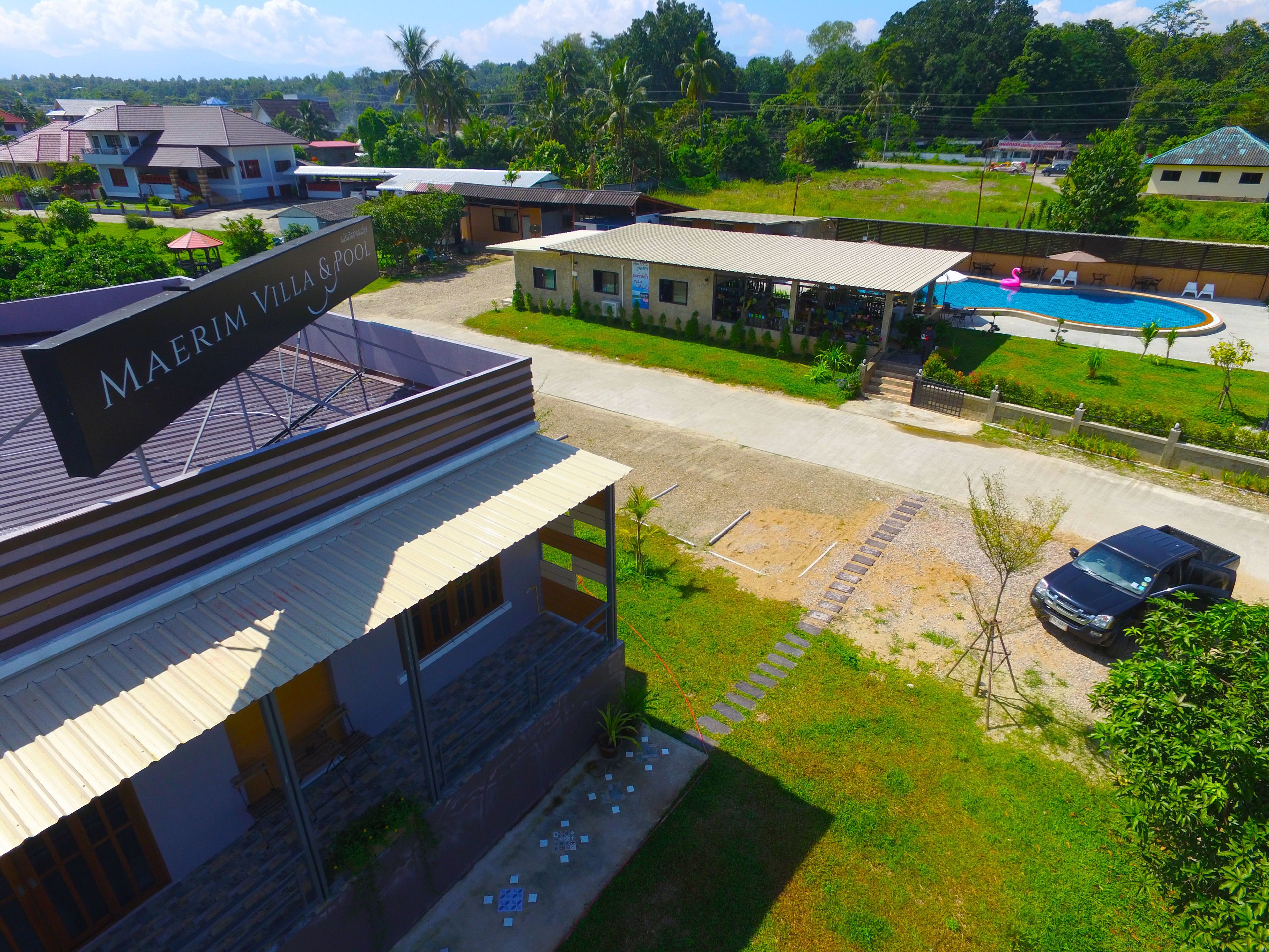 A hotel named Maerim Villa & Pool with a swimming pool, outdoor seating, and a view of the surrounding area.