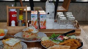 A table with various dishes including fried rice, waffles, and soup. There are also condiments and beverages on the table. - Maerim Villa & Pool (Mae Rim)