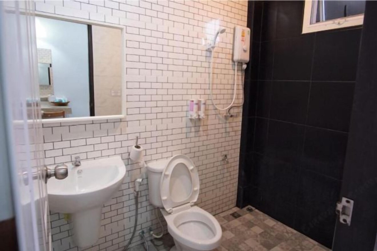 Un baño con lavamanos blanco, inodoro y zona de ducha.