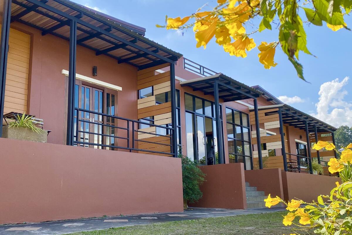 A modern building with large windows and a covered outdoor area.