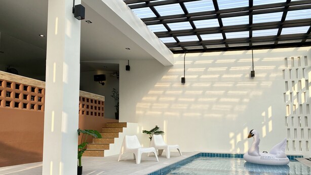 An indoor swimming pool with clear blue tiles, white chairs, and a swan inflatable on the edge. - Maerim Villa & Pool (Mae Rim)