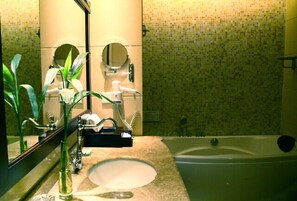 Ein Badezimmer mit Waschbecken, Spiegel und Badewanne.