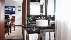Un baño moderno con un espejo grande, un lavamanos blanco y una silla de madera.