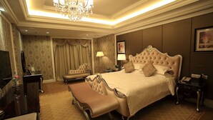 A spacious bedroom with a large bed, a vanity, a bench, and a chandelier. - Country Garden Phoenix Hotel, XingAnMeng (Xing'an)