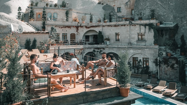 A resort with a pool, outdoor seating, and a mountainous backdrop. - Local Cave House Hotel (Nevsehir)