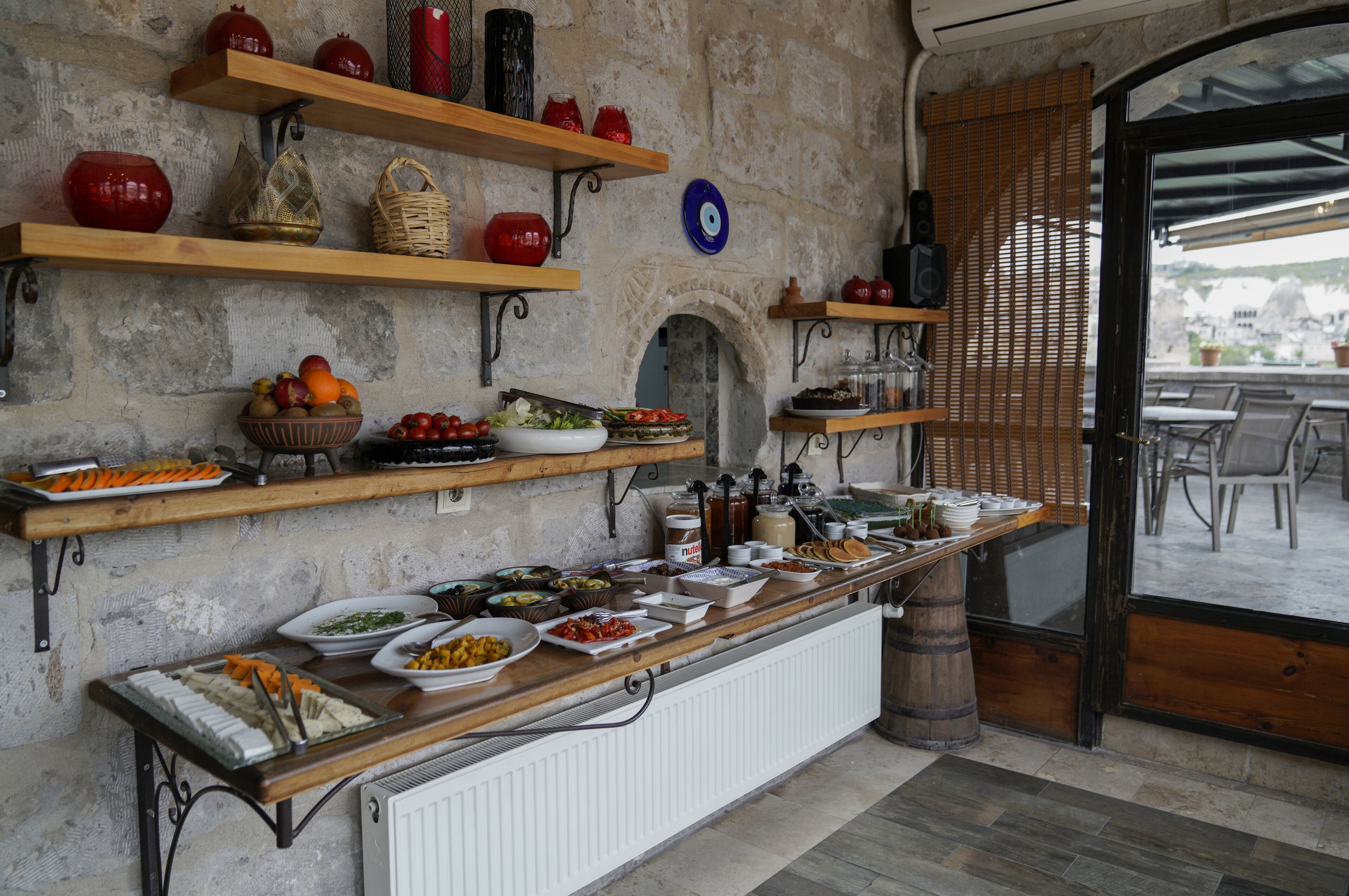 Montaje de bufé con diversos alimentos y objetos decorativos sobre estantes y mostradores.