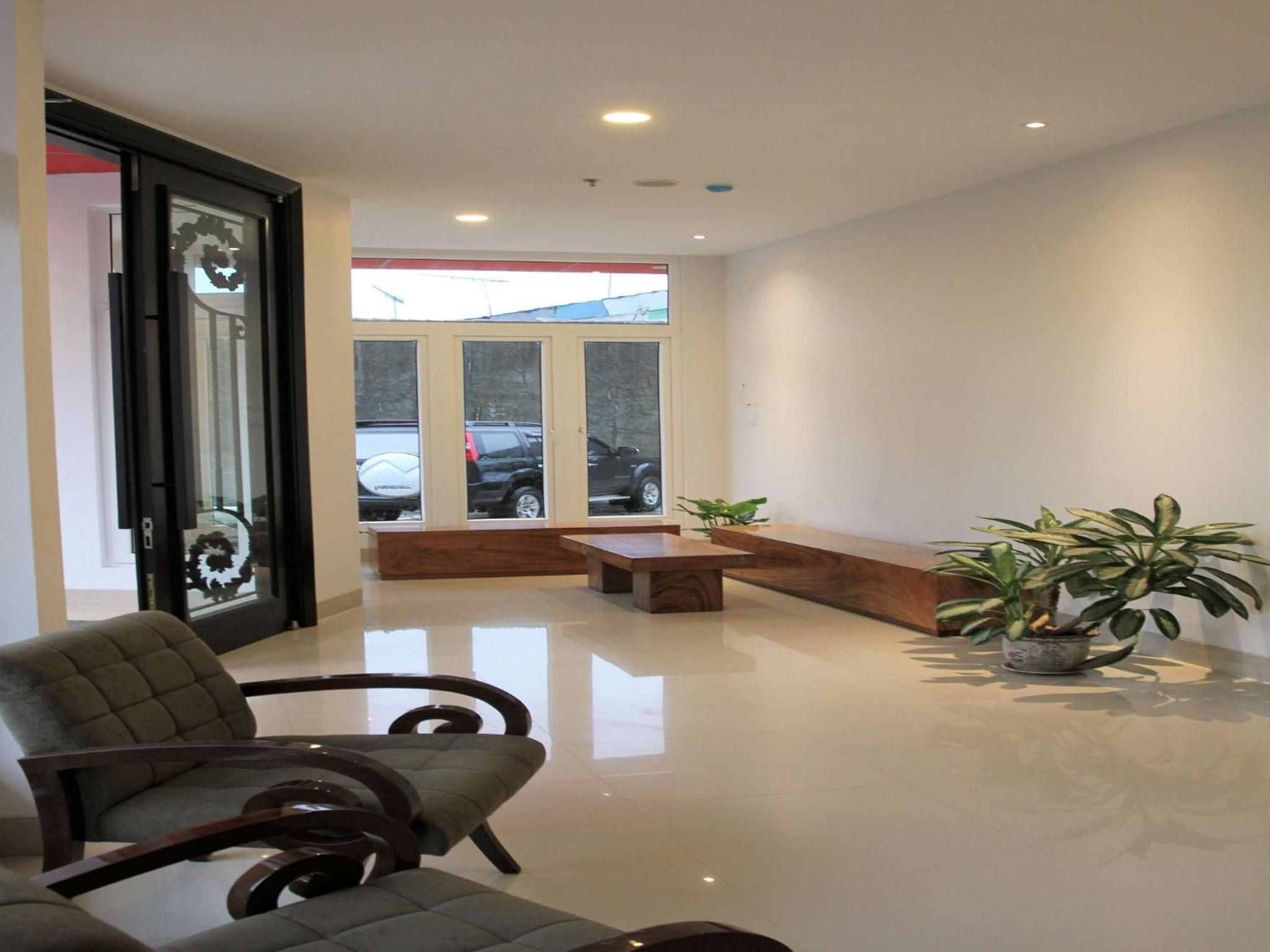 A modern interior with a seating area, a wooden bench, and a potted plant.
