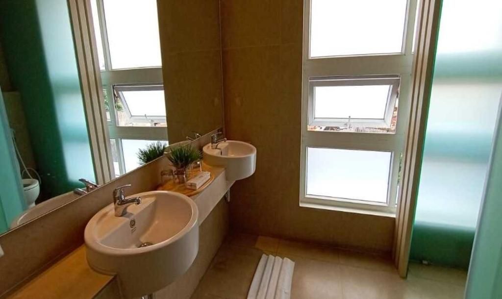 A bathroom with two sinks, a mirror, and a window.