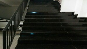 A set of black marble stairs with a metal railing, leading to an upper floor. - House Of Seya (Negombo)