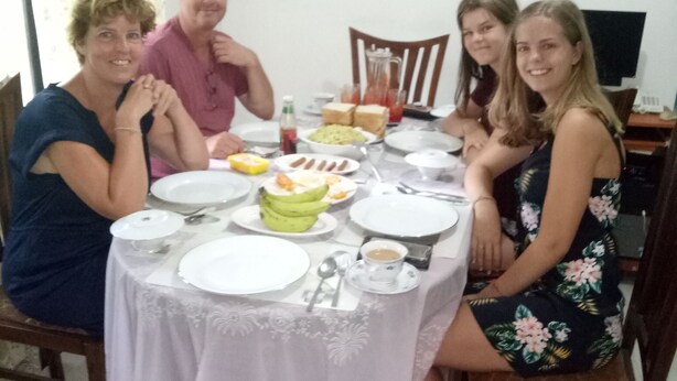 Una mesa de comedor con platos, tazones y una banana. Hay sillas alrededor de la mesa.
