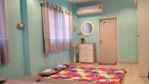 Un dormitorio con una cama, un aparador, un espejo y un equipo de aire acondicionado.