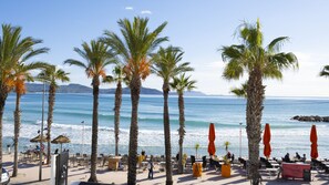 A beachfront restaurant with outdoor seating, palm trees, and ocean views. - A Deux Pas de l'Eau (La Ciotat)