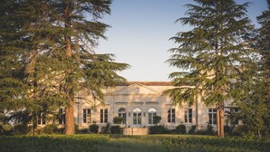 A stately building with a symmetrical facade, large windows, and a central entrance. - Haut-Bailly - La Chartreuse - Anciennement Château Le Pape (Leognan)