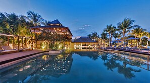 Una piscina al aire libre, sombrillas, sillones reclinables de piscina