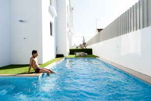 Una piscina al aire libre de temporada, tumbonas