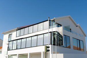 Un edificio moderno de dos pisos con grandes ventanales y techo plano.