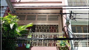Un bâtiment sur lequel est apposée une enseigne indiquant « QUANG GUESTHOUSE », ce qui signifie que des chambres sont à louer.