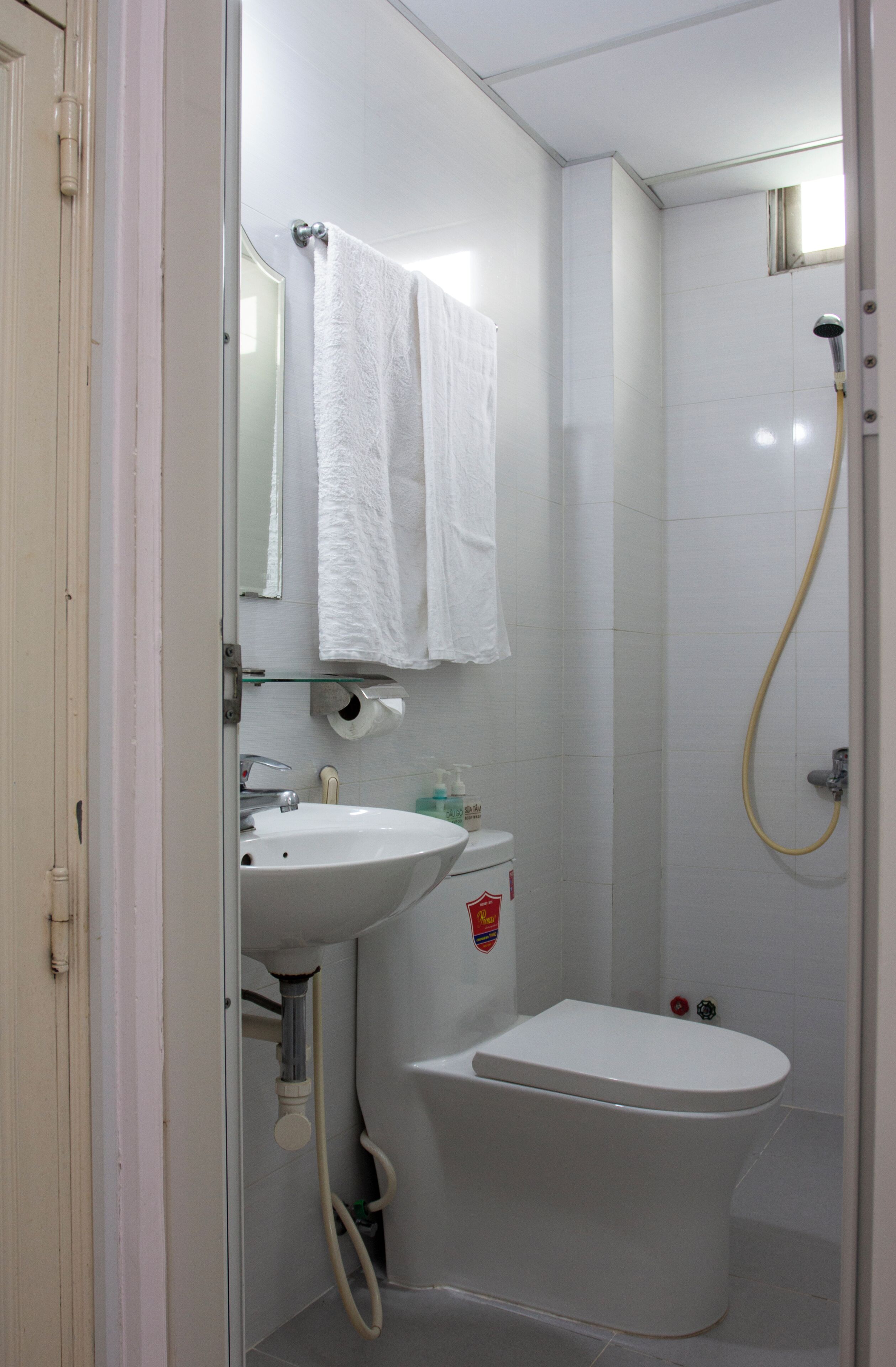 Une salle de bain avec un lavabo blanc, des toilettes et une douche.