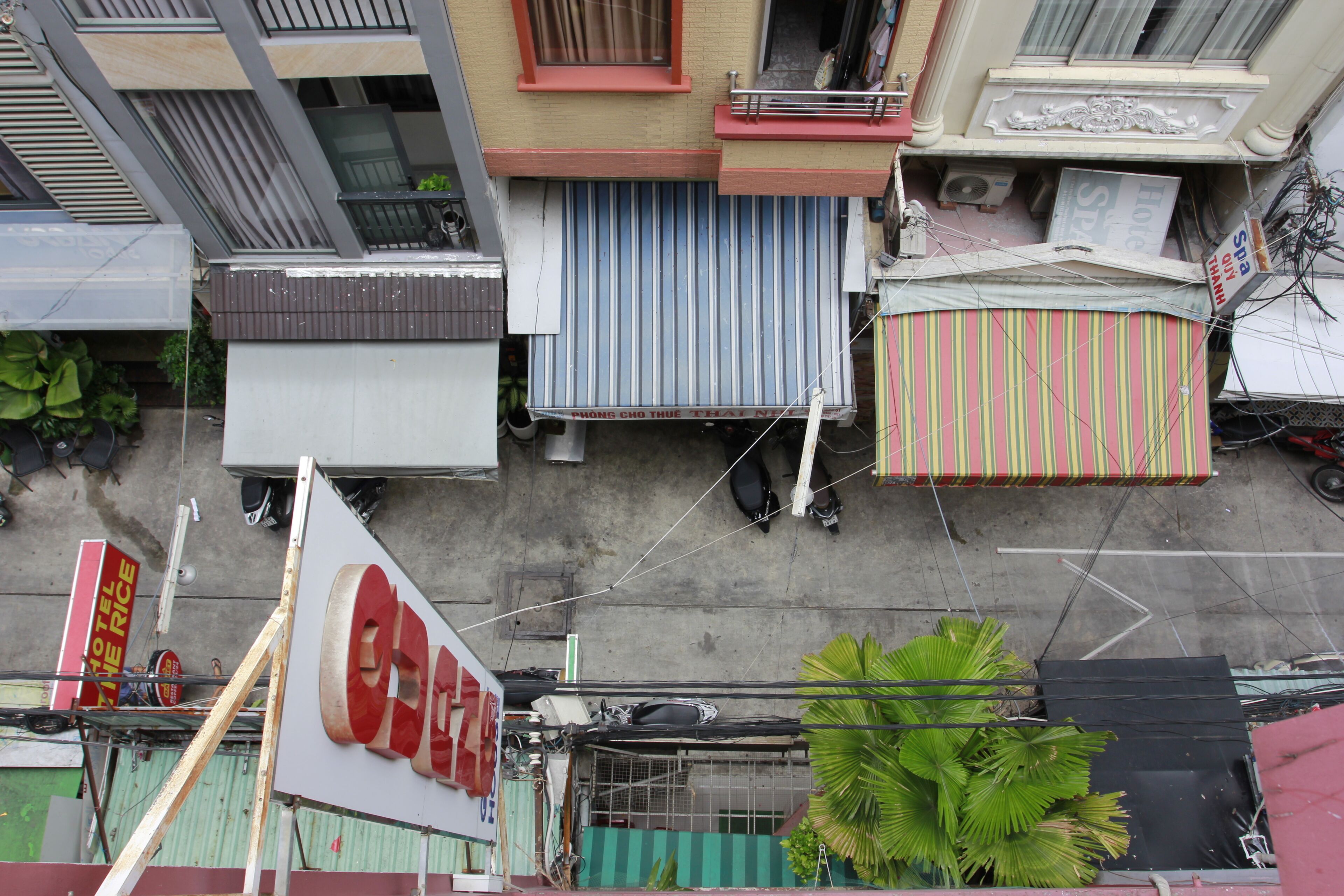 Vista da rua com vários edifícios, incluindo um hotel com uma placa visível.