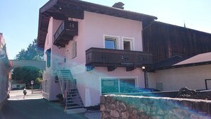 A two-story building with a balcony, a staircase, and a garage.