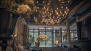 A modern interior with a bar area, seating, and a large window with a view. - Merton Hotel Ipoh (Ipoh)
