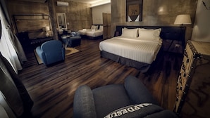 A hotel room with a large bed, a desk with a chair, a sofa, and a wardrobe. - Merton Hotel Ipoh (Ipoh)