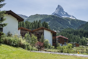 A mountain lodge with wooden cabins and a view of a prominent mountain peak. - Ferienhaus Casa Luna (Zermatt)