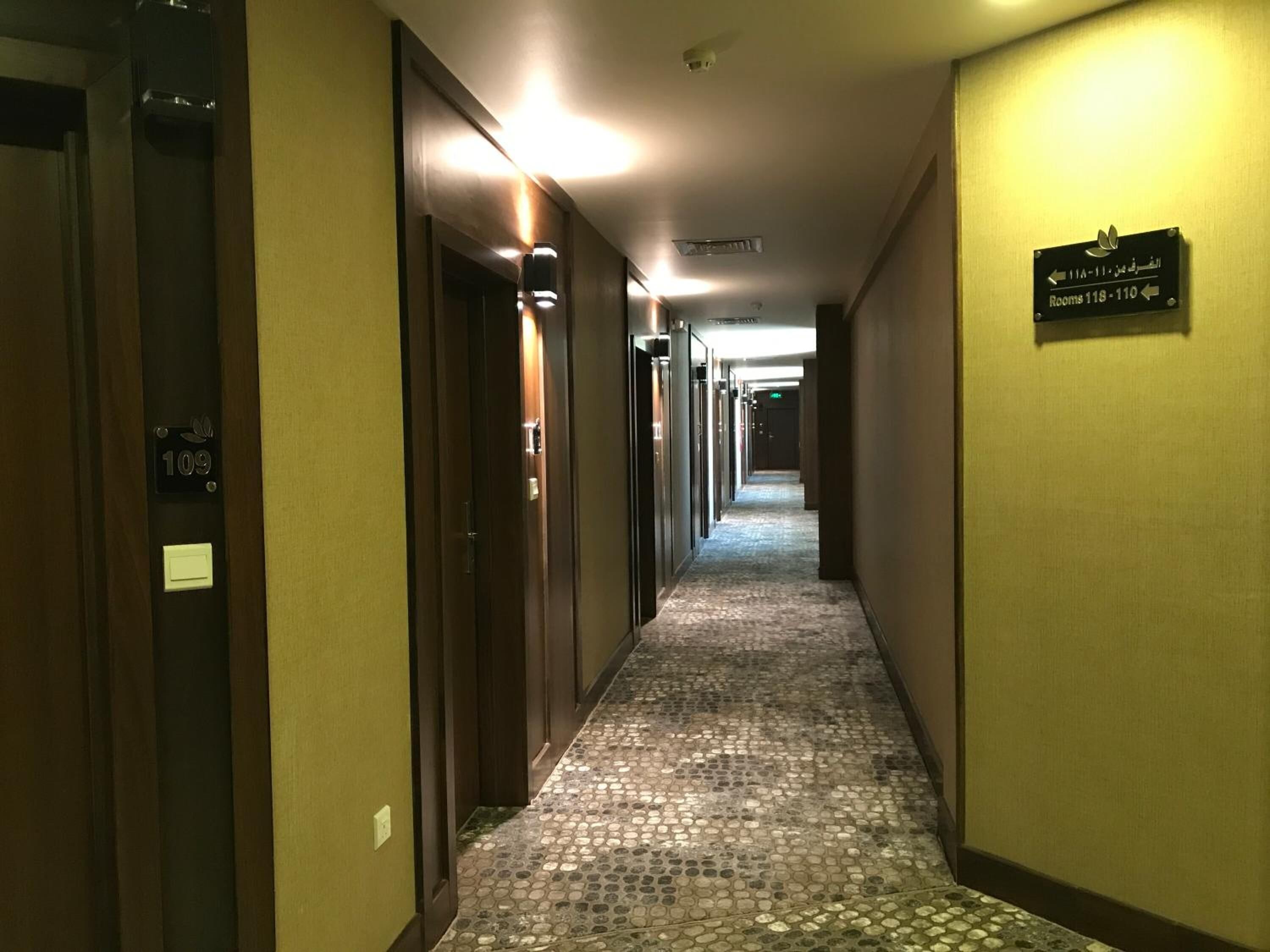 A hotel hallway with doors numbered 109 and 110, leading to rooms 118-110.